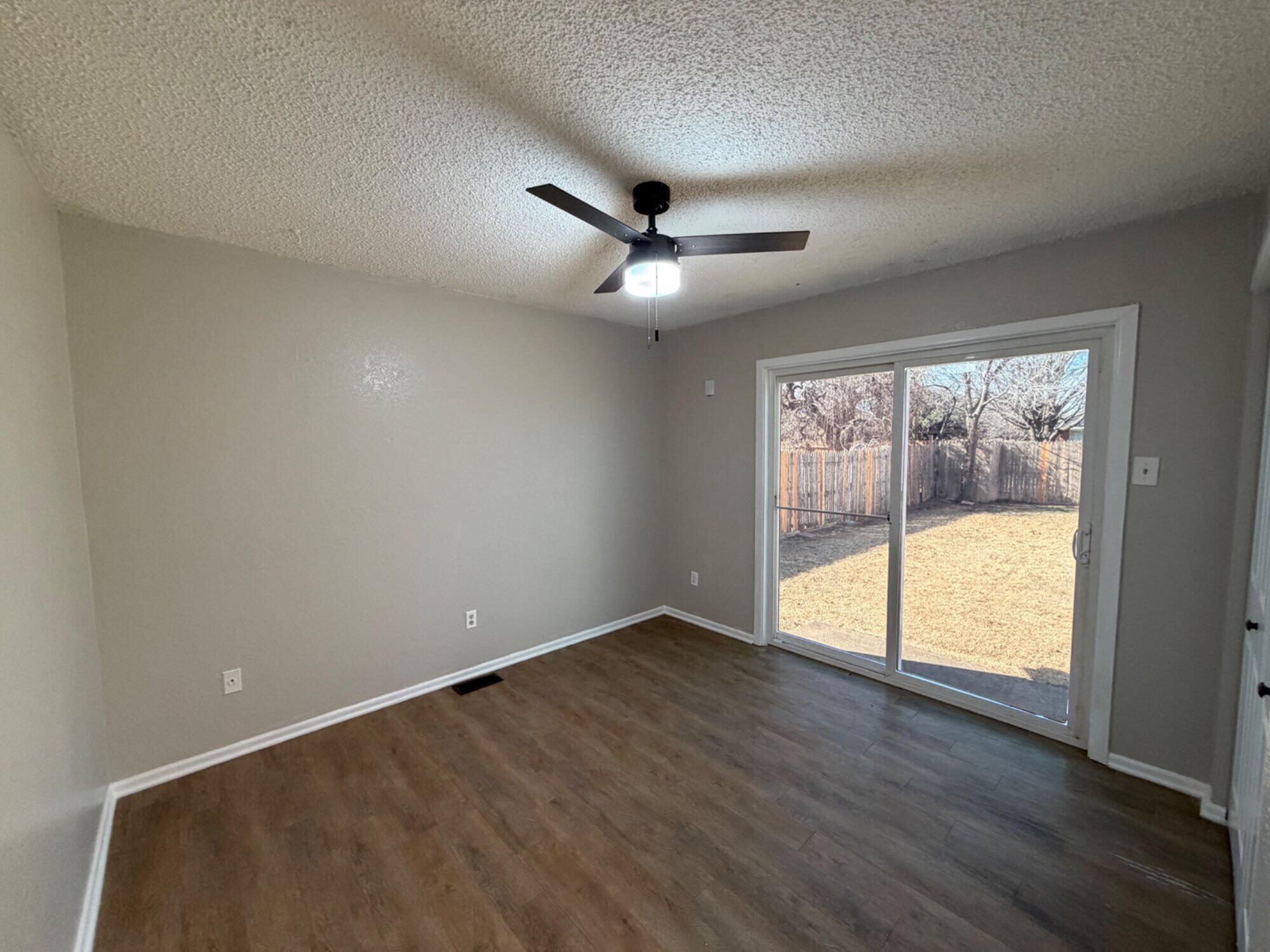 9604 Elgin Avenue, Unit B Lubbock, TX 79423 - Photo 10 of 12 an empty room with wooden floor and windows