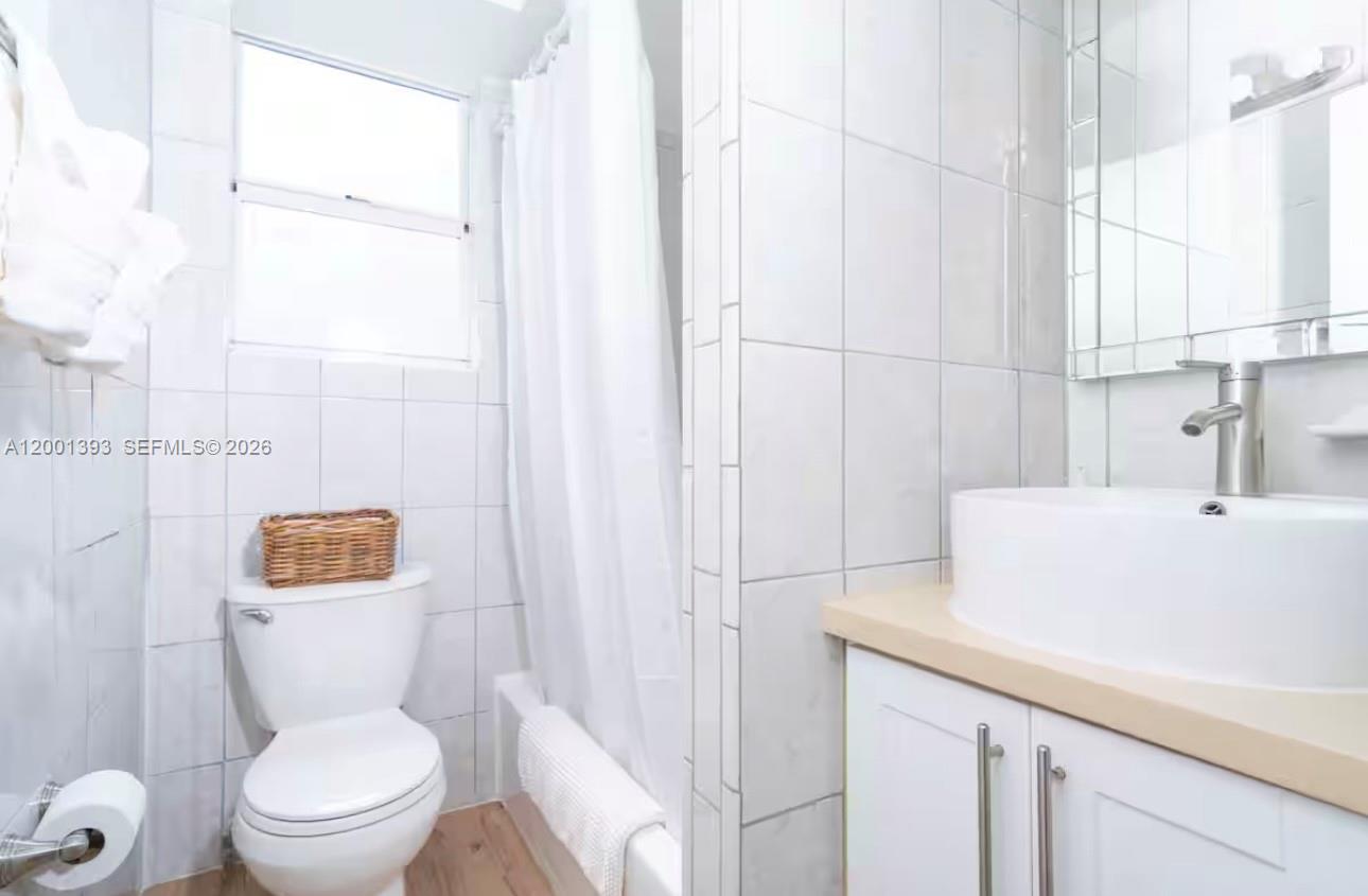 227 1st Street, Unit 7 Miami Beach, FL 33139 - Photo 12 of 12 a white toilet sitting next to a bathroom sink