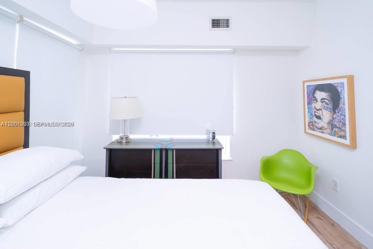 227 1st Street, Unit 7 Miami Beach, FL 33139 - Photo 7 of 12 a bedroom with a bed and a wall painting