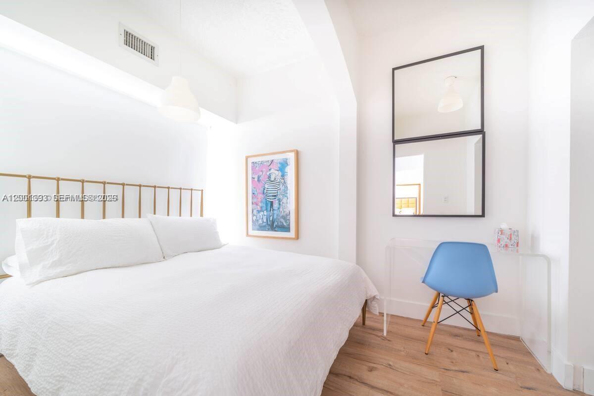 227 1st Street, Unit 7 Miami Beach, FL 33139 - Photo 8 of 12 a bedroom with a bed and a chandelier