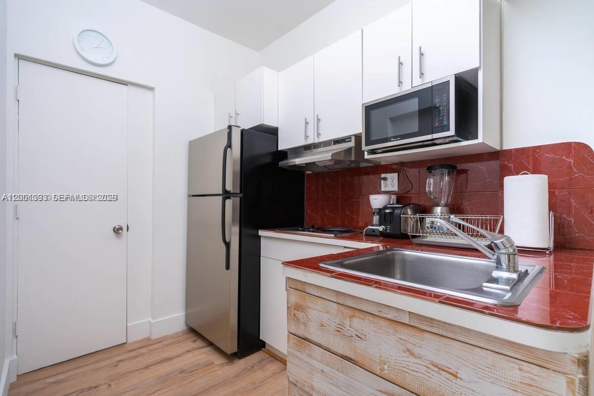 227 1st Street, Unit 7 Miami Beach, FL 33139 - Photo 9 of 12 a kitchen with a refrigerator sink and microwave