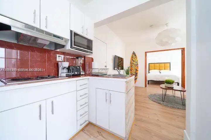 227 1st Street, Unit 7 Miami Beach, FL 33139 - Photo 10 of 12 a kitchen with cabinets and outdoor view