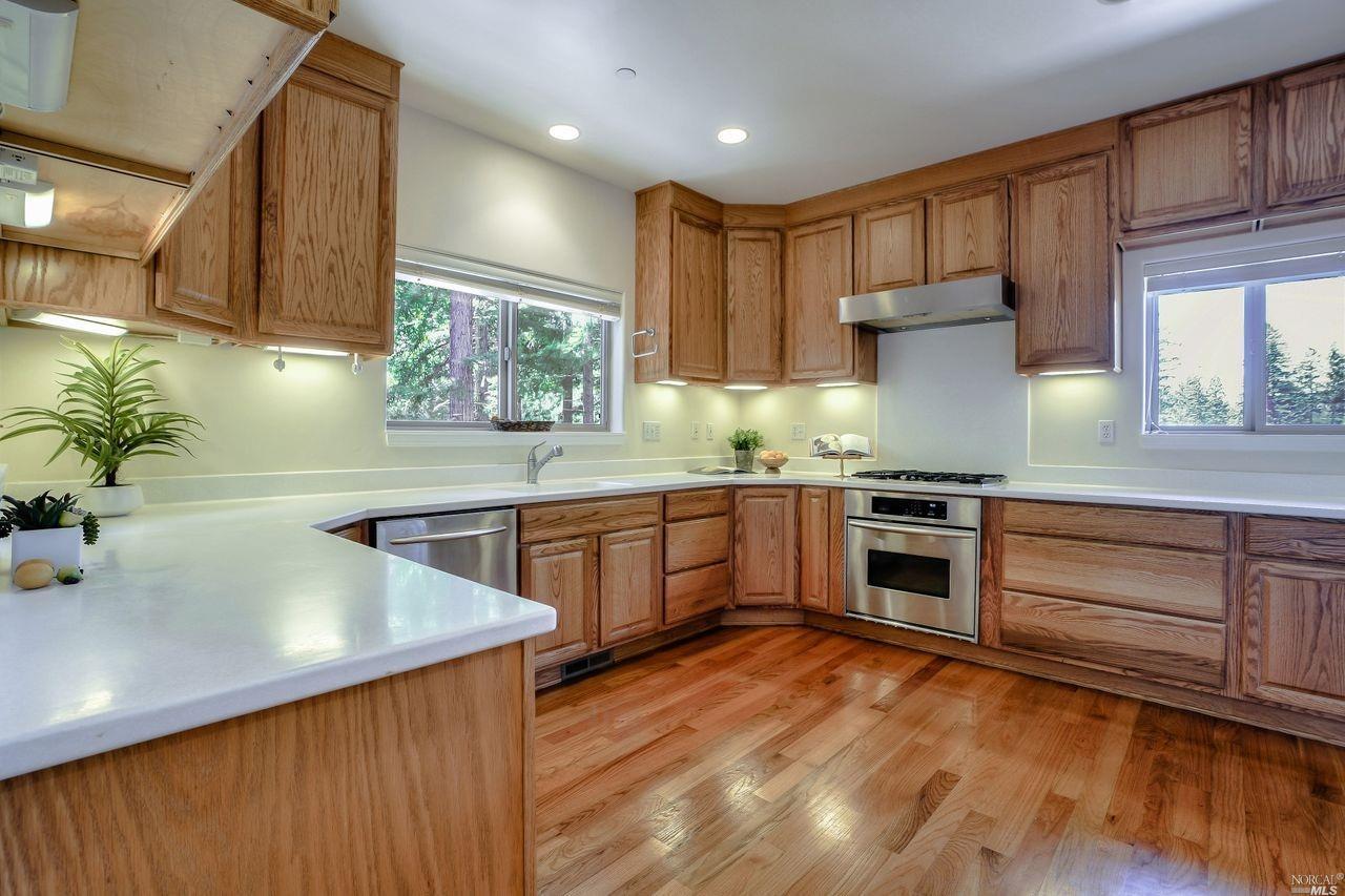 a kitchen with stainless steel appliances a sink cabinets and wooden floor
