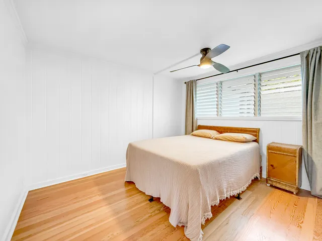 a bedroom with a bed and wooden floor