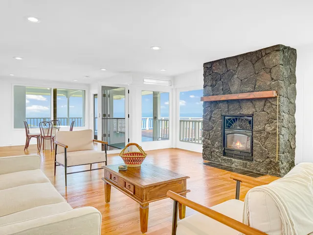 a living room with furniture a fireplace and a large window