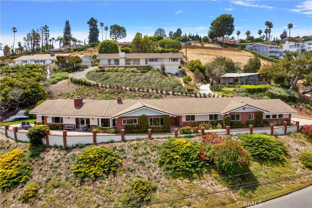 an aerial view of a house with swimming pool and outdoor seating