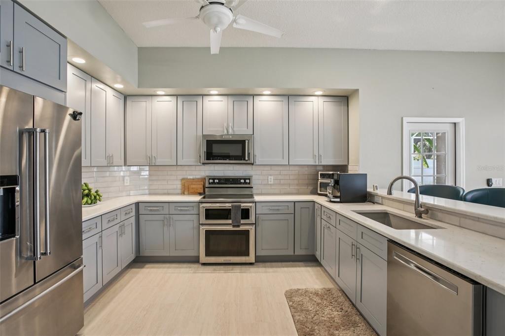 2903 Mossy Timber Trail Valrico, FL 33596 - Photo 11 of 39 a kitchen with stainless steel appliances a sink stove refrigerator and cabinets