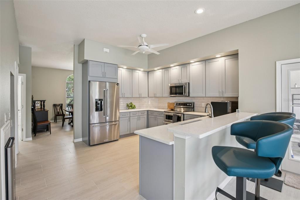 2903 Mossy Timber Trail Valrico, FL 33596 - Photo 8 of 39 a kitchen with refrigerator a microwave and furniture