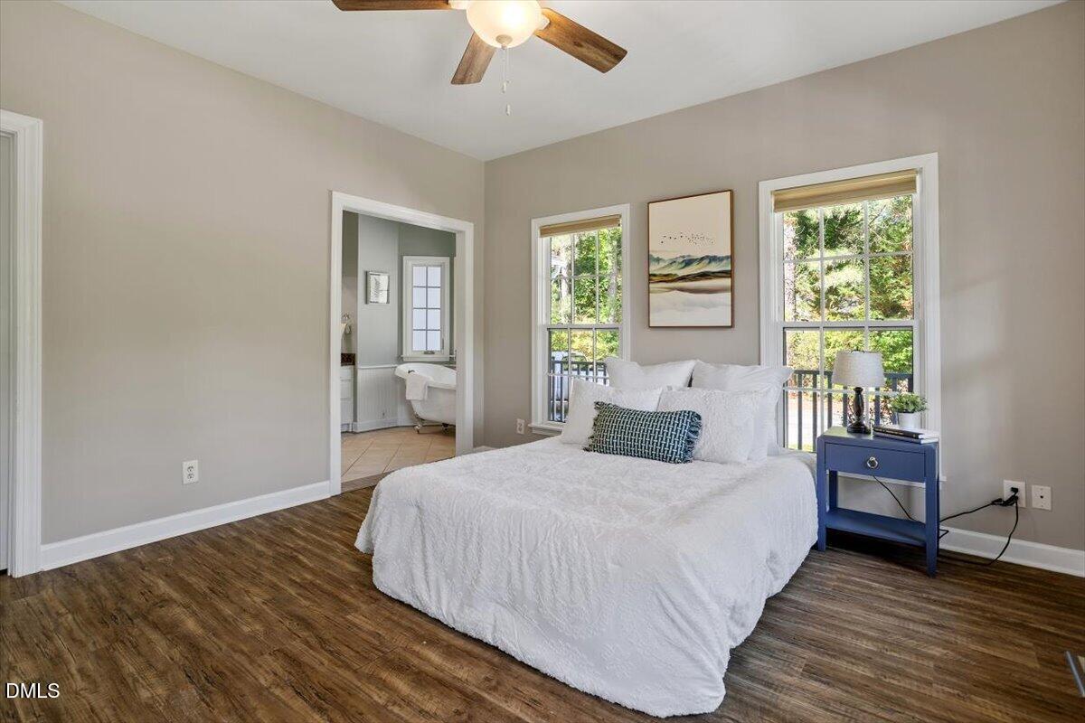 7505 Penny Road Raleigh, NC 27606 - Photo 27 of 35 a bedroom with a bed and a large window with wooden floor