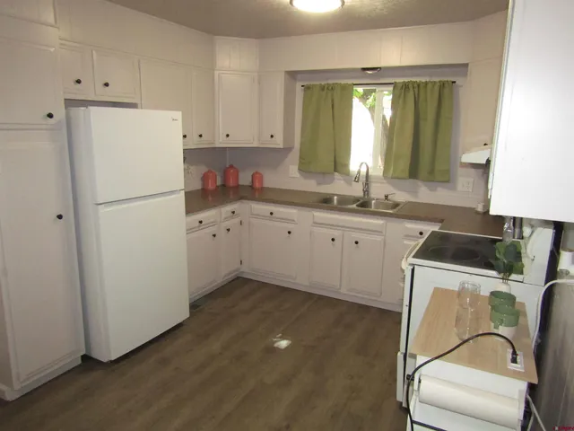 a kitchen with a refrigerator sink and white cabinets