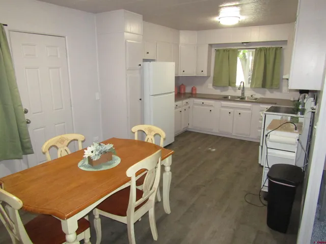 a kitchen with a table chairs and a refrigerator