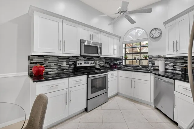 a kitchen with stainless steel appliances granite countertop a refrigerator and a stove top oven
