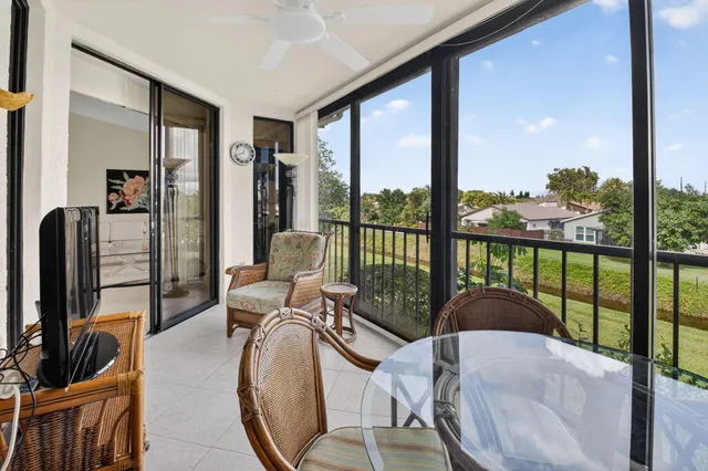 a view of a big yard with potted plants and a large tree