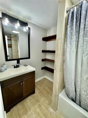 a bathroom with a double vanity sink mirror and shower