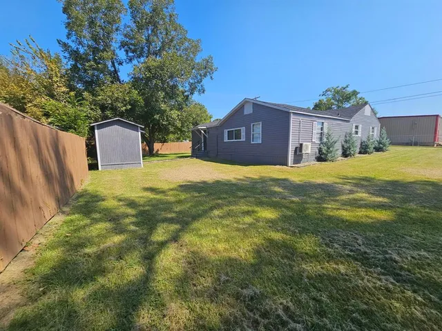 a house view with a big yard plants and large trees