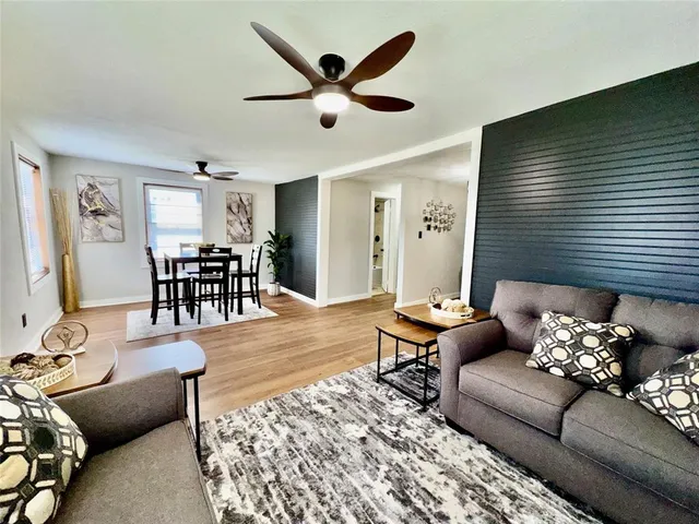 a living room with furniture wooden floor and dining table