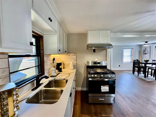 a kitchen with granite countertop a stove and a sink
