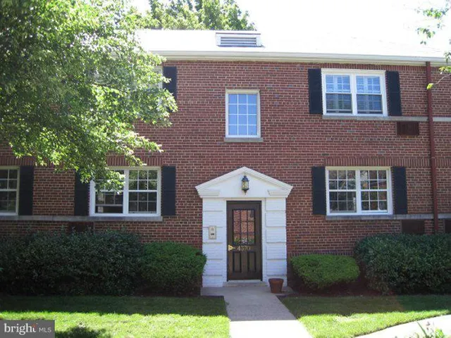 a front view of a house with yard and glass windows
