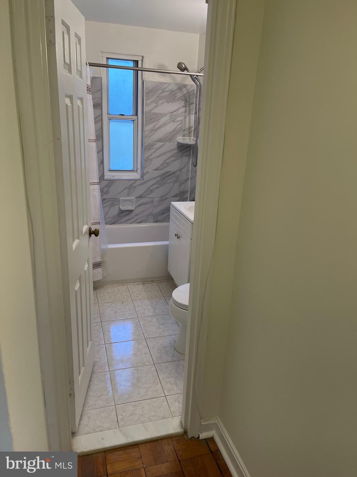 4370 North Pershing Drive, Unit 2 Arlington, VA 22203 - Photo 5 of 17 a bathroom with a granite countertop shower and a toilet
