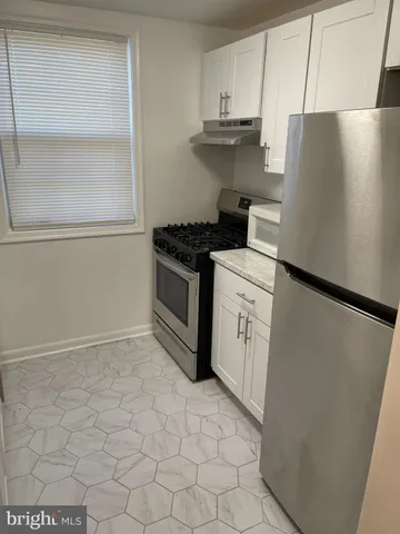 a kitchen with a stove top oven and cabinets