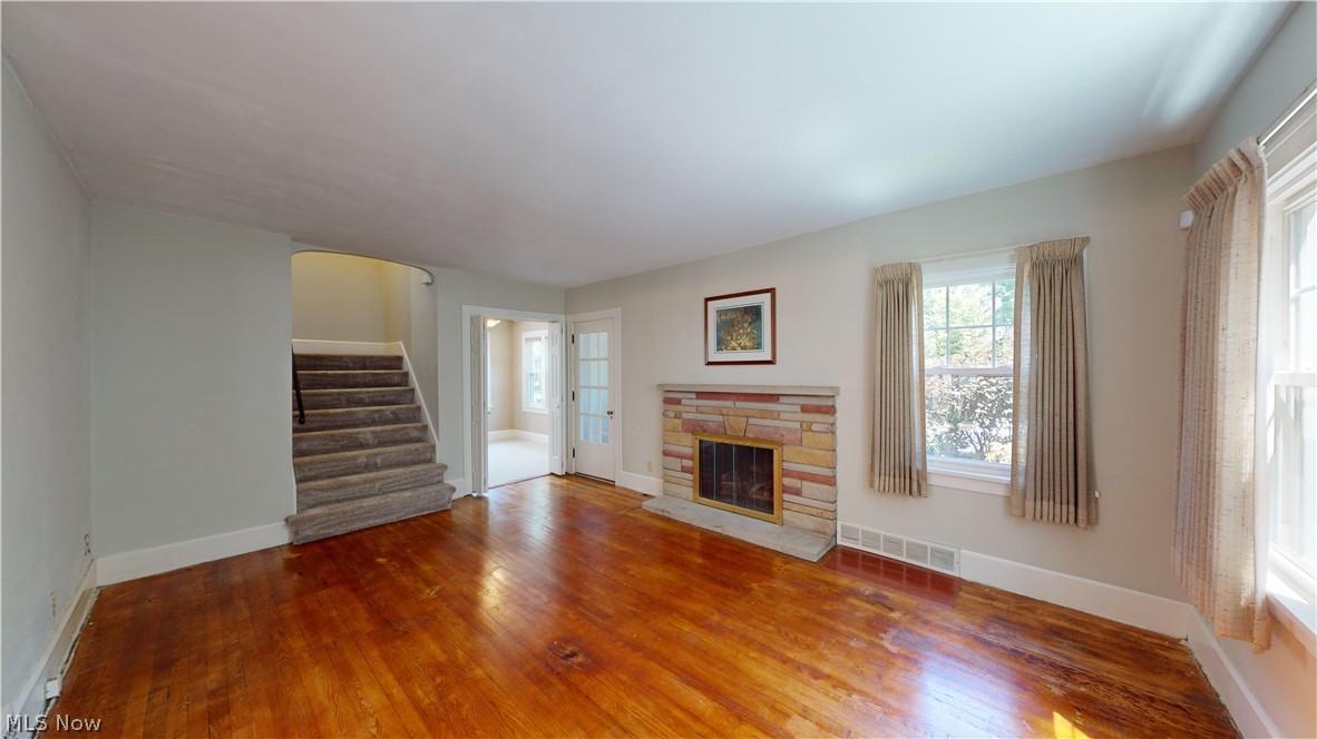 3988 Navahoe Road Cleveland Heights, OH 44121 - Photo 6 of 31 Unfurnished living room featuring wood-type flooring and a stone fireplace