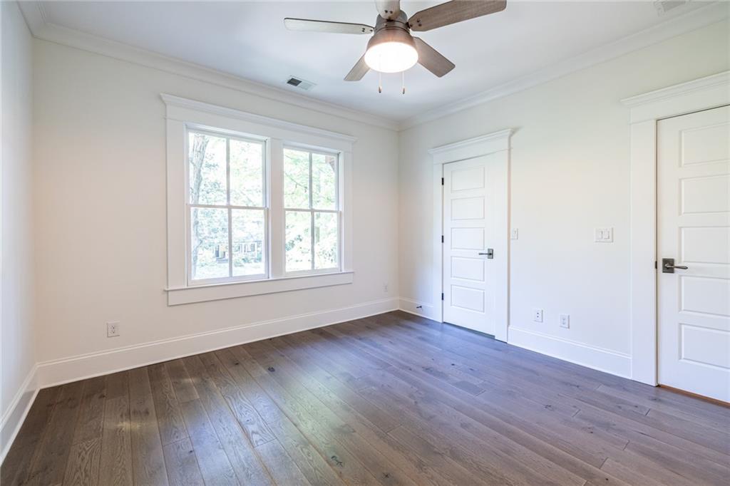 538 Ansley Street Decatur, GA 30030 - Photo 49 of 73 an empty room with wooden floor chandelier fan and windows