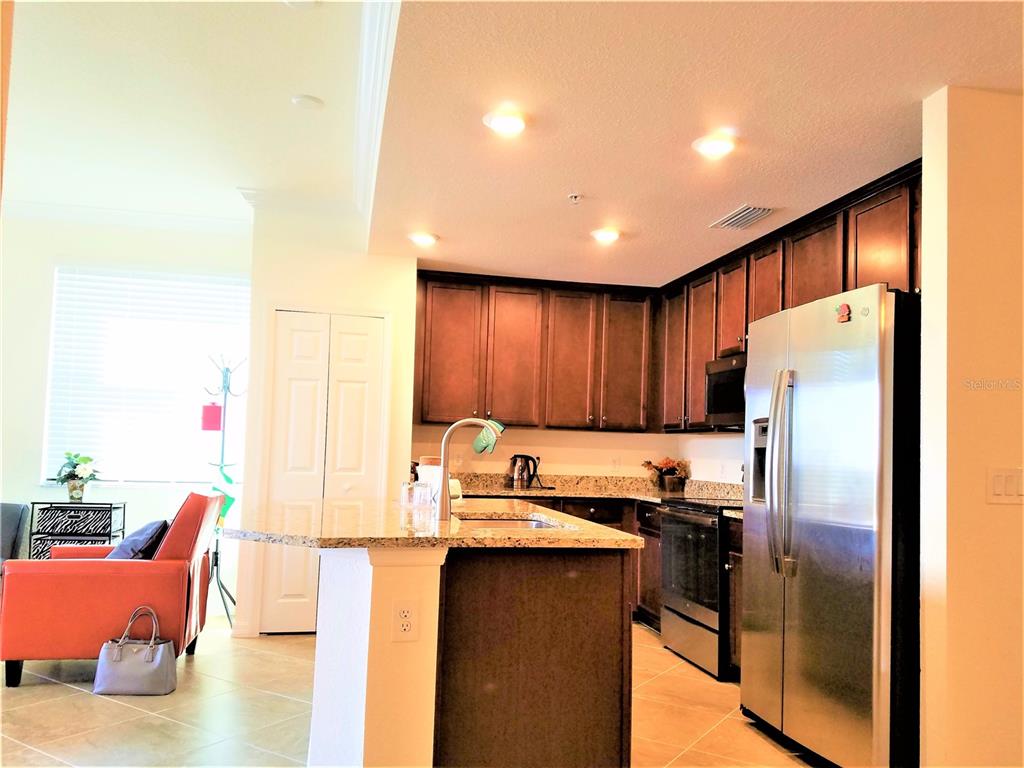 17108 Vardon Terrace, Unit 208 Lakewood Ranch, FL 34211 - Photo 3 of 14 a kitchen with refrigerator and cabinets