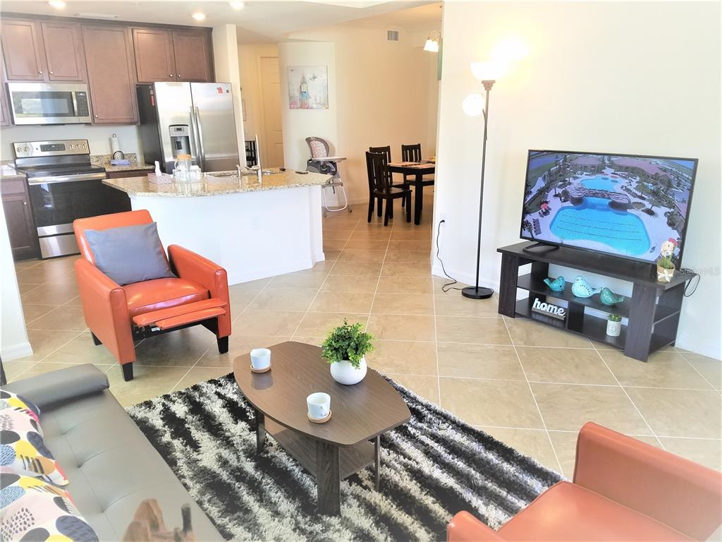 17108 Vardon Terrace, Unit 208 Lakewood Ranch, FL 34211 - Photo 5 of 14 a living room with furniture and a dining table with kitchen view