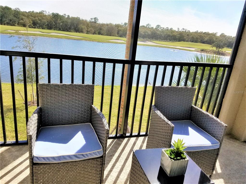 17108 Vardon Terrace, Unit 208 Lakewood Ranch, FL 34211 - Photo 6 of 14 a balcony with wooden floor and outdoor seating