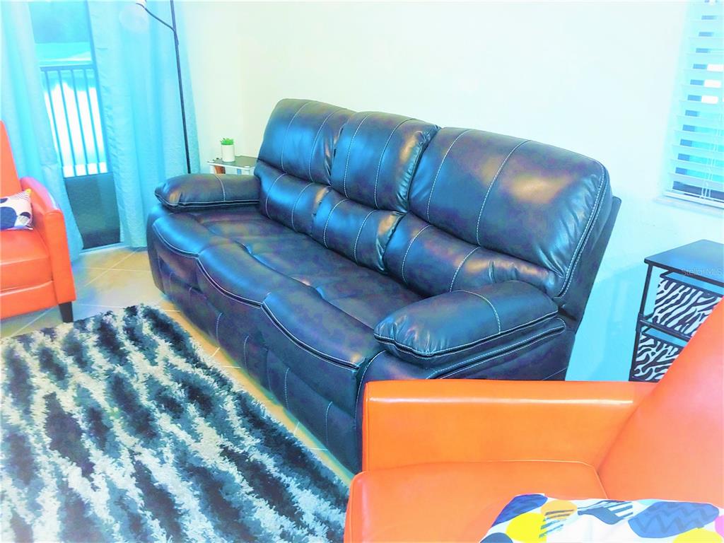 17108 Vardon Terrace, Unit 208 Lakewood Ranch, FL 34211 - Photo 8 of 14 a blue couch sitting in a room next to a blue wall