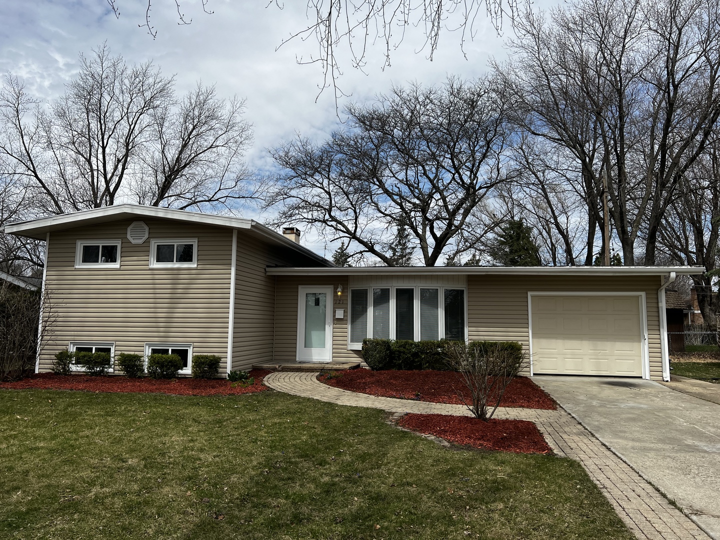 a front view of a house with a yard and trees