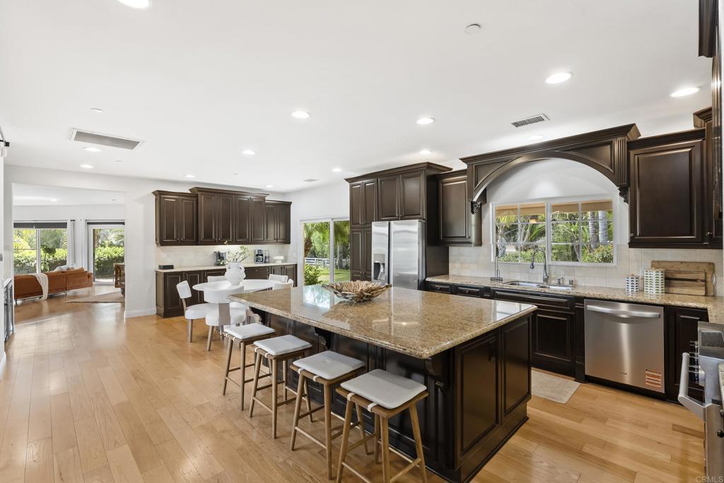 17412 La Brisa Rancho Santa Fe, CA 92067 - Photo 7 of 37 a open kitchen with stainless steel appliances granite countertop a stove refrigerator and a view of living room
