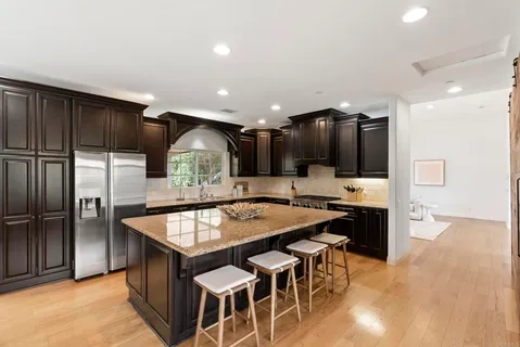 a kitchen with granite countertop wooden cabinets and stainless steel appliances