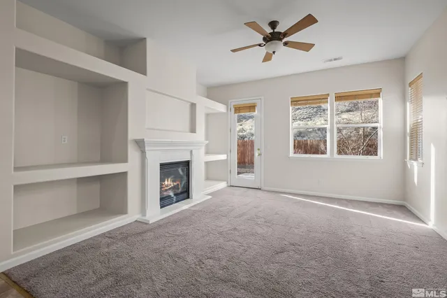 a view of a livingroom with a fireplace and a window