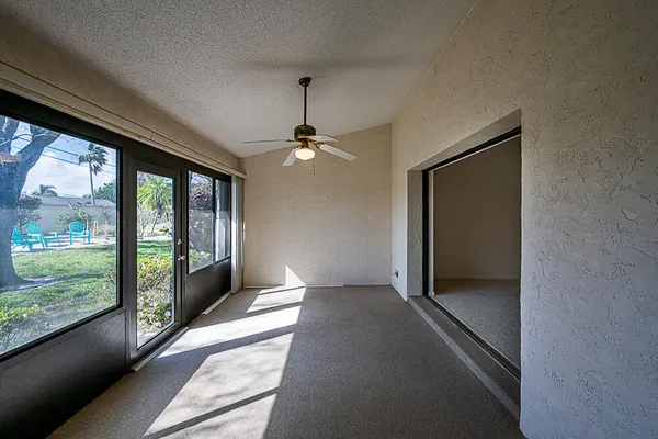 a view of a big room with windows and chandelier fan