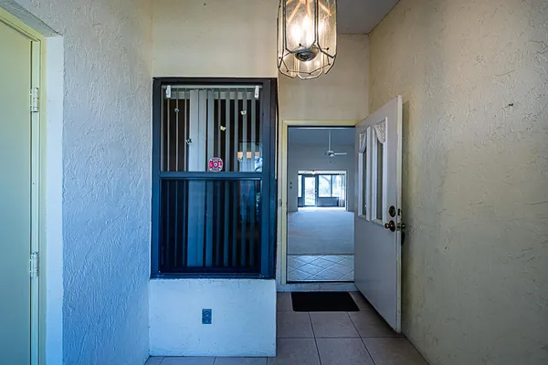an empty room with windows and ceiling fan