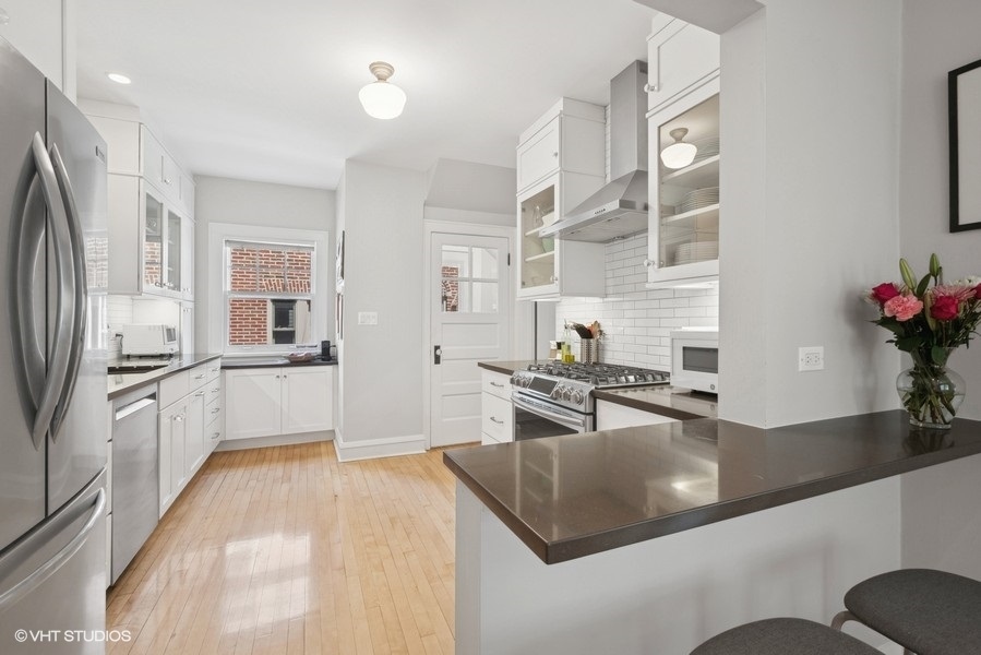 2206 Forestview Road Evanston, IL 60201 - Photo 6 of 32 a kitchen with stainless steel appliances granite countertop a sink refrigerator and cabinets