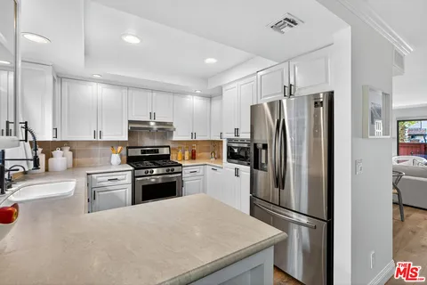 a kitchen with granite countertop stainless steel appliances and refrigerator