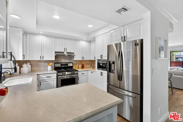 a kitchen with granite countertop stainless steel appliances and refrigerator
