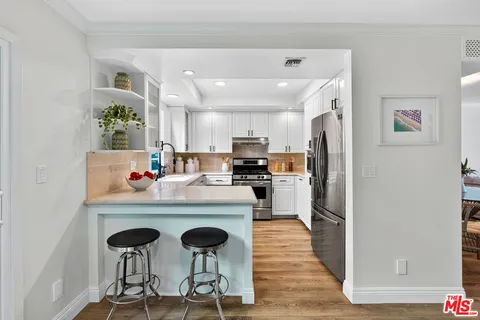 a kitchen with a refrigerator a stove a sink dishwasher and a refrigerator with wooden floor