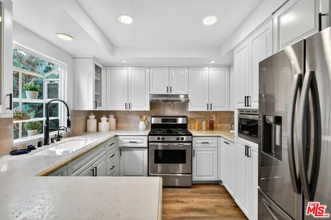 a kitchen with a stove a sink and a refrigerator
