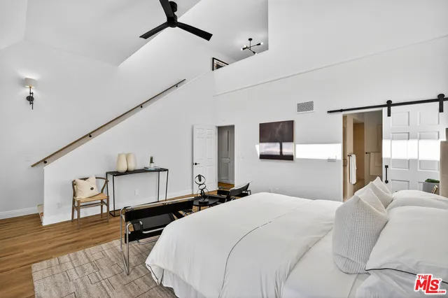 a bedroom with a bed a mirror and couch