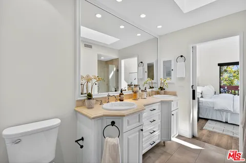 a spacious bathroom with a double vanity sink toilet and mirror