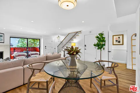 a living room with furniture a chandelier and a floor to ceiling window