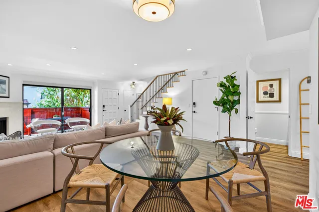 a living room with furniture a chandelier and a floor to ceiling window