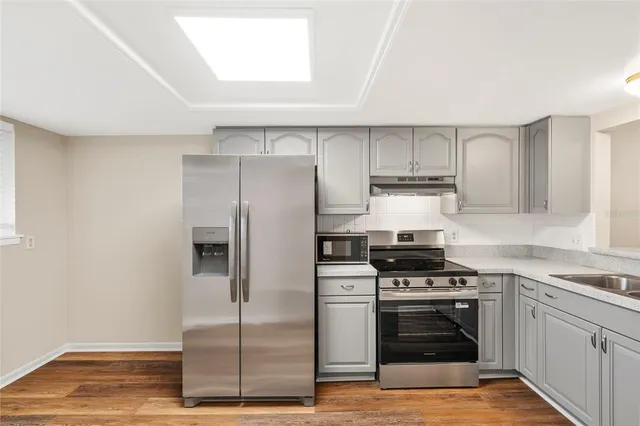 a kitchen with stainless steel appliances granite countertop a stove a sink and a refrigerator