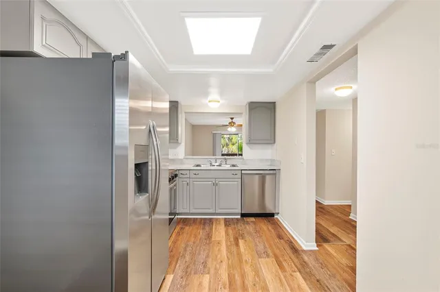 a empty room with wooden floor and a ceiling fan