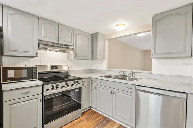 a kitchen with stainless steel appliances granite countertop a sink and a refrigerator