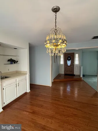 a view of a kitchen with a chandelier cabinetry a sink and a chandelier