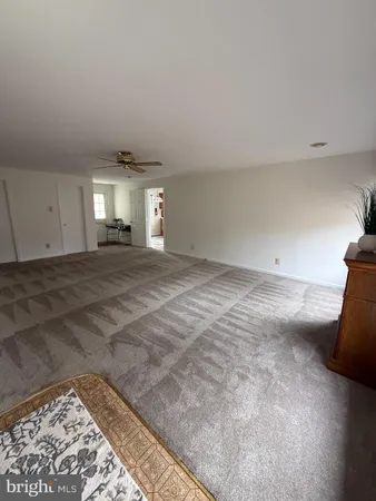 a view of a livingroom with an empty space and a rug